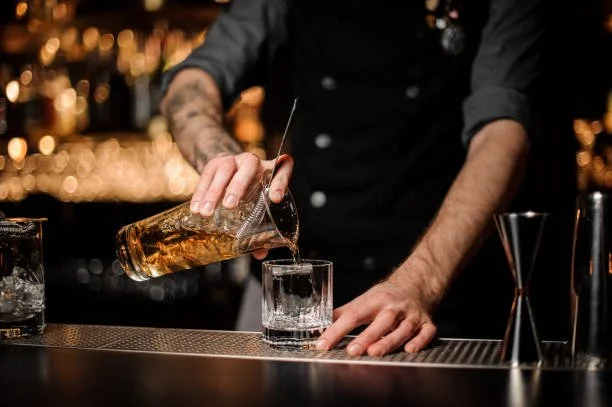 A bartender pouring an original cocktail at Whiskey & Water, the seafood restaurant and bourbon bar in downtown Blue Ridge, Georgia