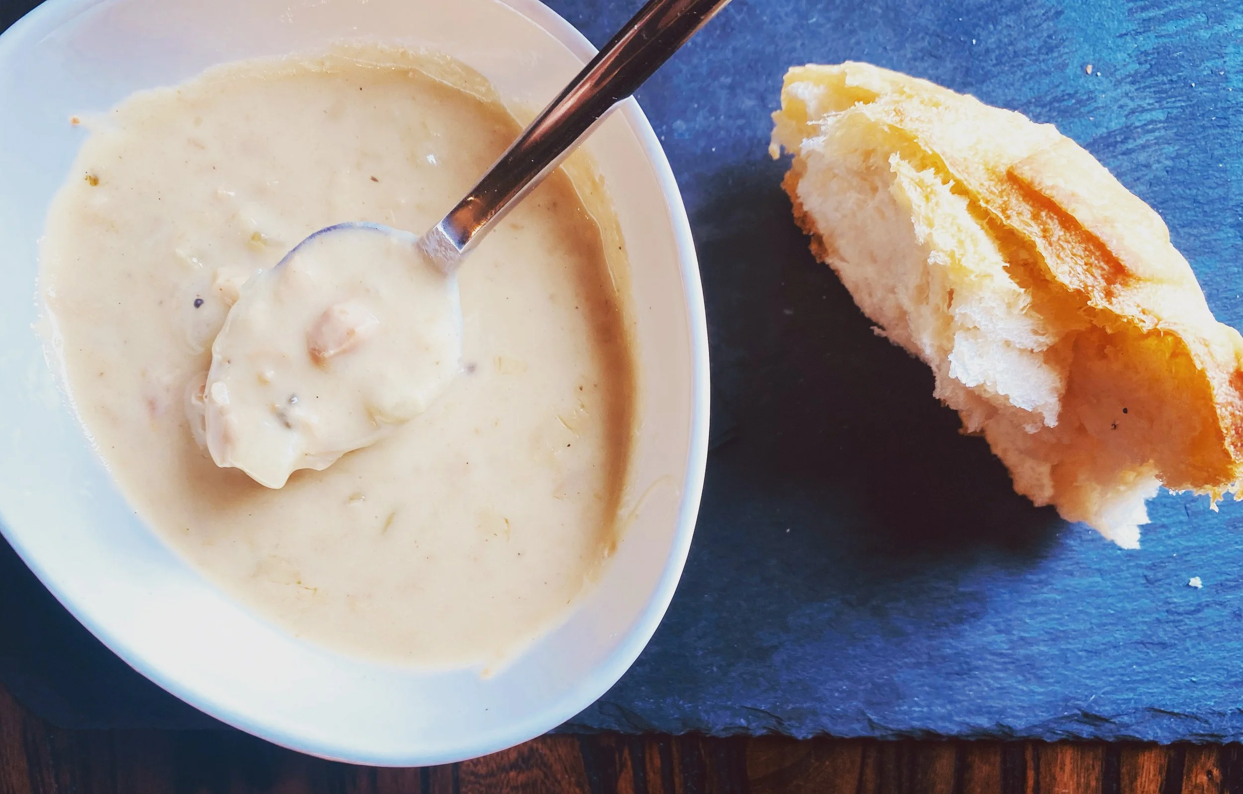 A bowl of creamy chowder served with bread at Whiskey & Water